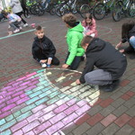 chłopcy rysują na chodniku ogromne kolorowe jabłko.JPG