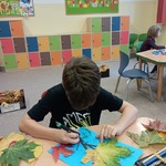 uczeń podczas wykonywania pracy z wykorzystaniem liści.jpg