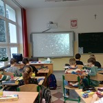 uczniowie klasy drugiej z uwagą oglądają zdjęcia przestrzeni kosmicznej.jpg