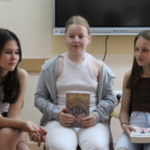 Uczennice klasy 5 SP prezentują swoje książki podczas spotkania Klubu Dyskusyjnego.png