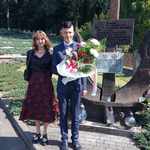 Uczniowie z kwiatami na cmentarzu wojennym.jpg
