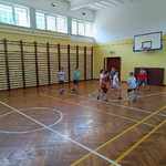 grupa uczniów_ grająca w piłkę nożną podczas zajęć sportowych na sali gimnastycznej.jpg