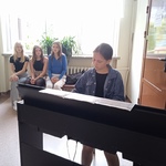 uczennica Iga gra na pianinie_ w dali siedzą trzy uczennice.jpg
